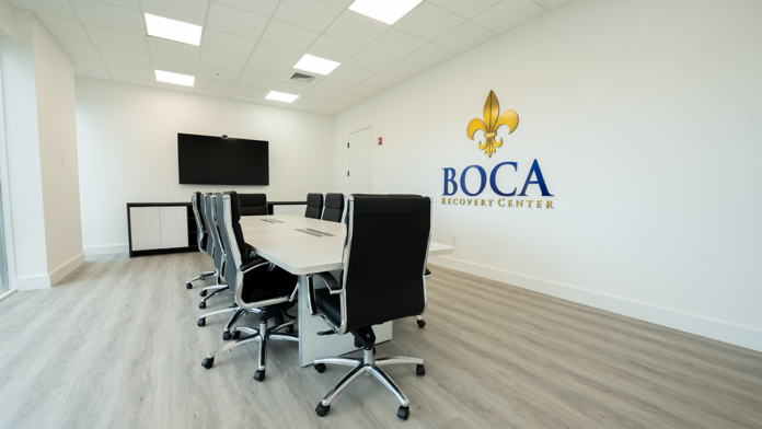 Modern conference room at Boca Recovery Center equipped with a large screen and meeting table.