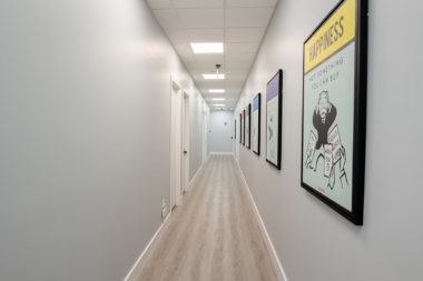 A bright, clean hallway at the Boca Recovery Center facility featuring colorful wall art.