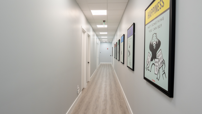 A bright, clean hallway at the Boca Recovery Center facility featuring colorful wall art.