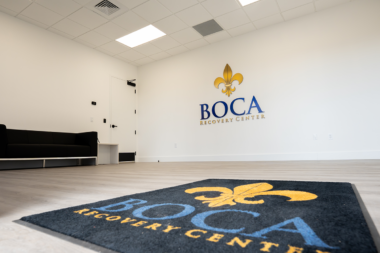 Boca Recovery Center lobby space featuring a branded welcome mat and matching 3D wall logo.