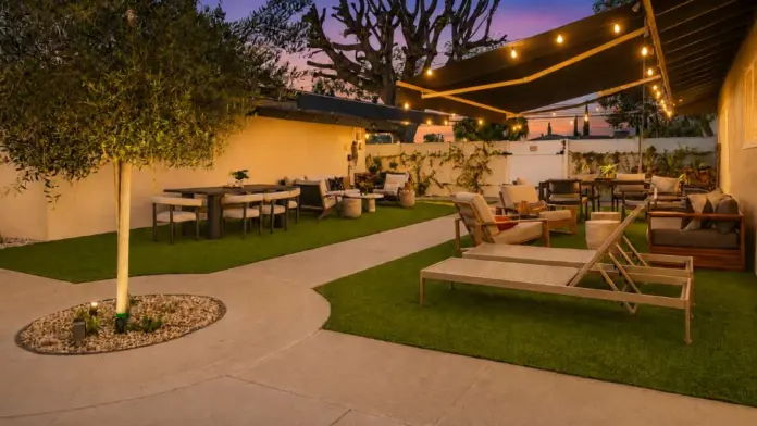 Courtyard at Recovery Beach at dusk with an olive tree, string lights, and multiple outdoor seating areas