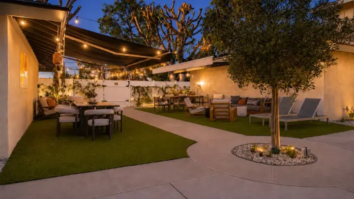 Courtyard at Recovery Beach at dusk featuring an olive tree, dining area, and lounge seating