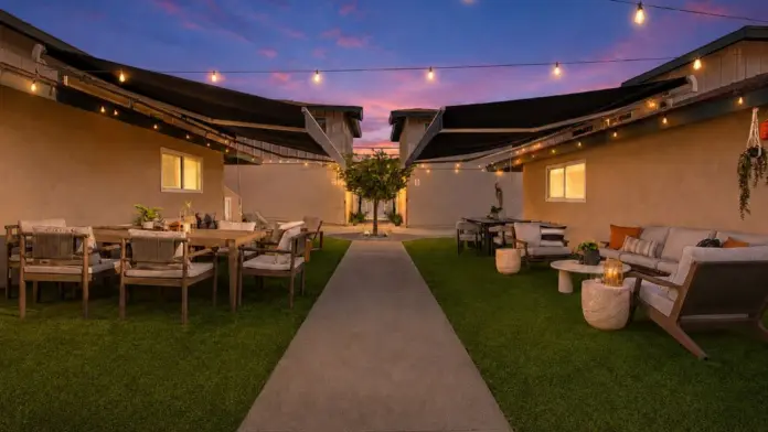 Courtyard at Recovery Beach at sunset with a walkway, string lights, and outdoor seating areas