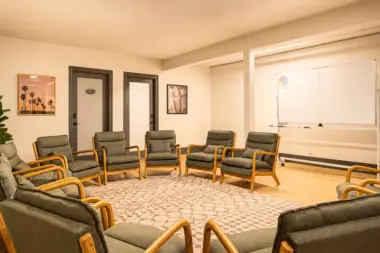 Group therapy room at Recovery Beach with chairs arranged in a circle and a whiteboard