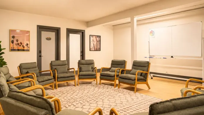 Group therapy room at Recovery Beach with chairs arranged in a circle and a whiteboard