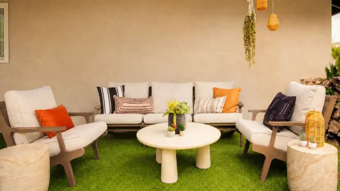 Outdoor patio lounge at Recovery Beach with cream sofas, wood armchairs, and artificial turf
