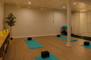 Yoga studio at Recovery Beach with mats laid out around a center support column and sheer curtain divider