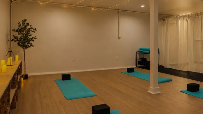 Yoga studio at Recovery Beach with mats laid out around a center support column and sheer curtain divider