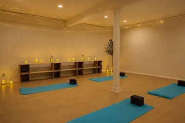 Yoga studio at Recovery Beach with teal mats, string lights, and candlelit decor