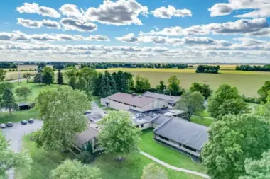 Aerial view of the Woodland Grove Recovery campus with multiple buildings, green space, trees, and surrounding fields.