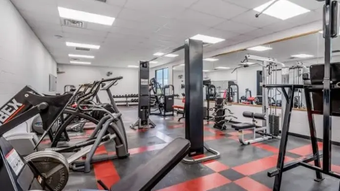 Fitness center at Woodland Grove Recovery with cardio machines, weight equipment, benches, and strength training equipment.