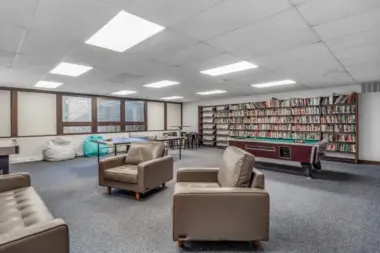 Game room at Woodland Grove Recovery with ping pong, pool, bookshelves, seating, and recreational space.