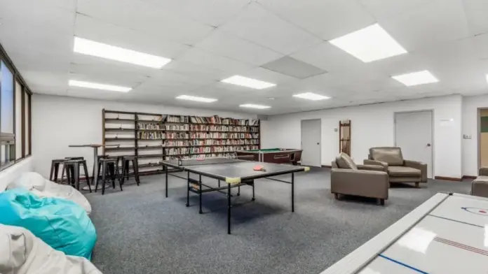 Woodland Grove Recovery recreation room featuring a ping pong table, pool table, bookshelves, and lounge seating.