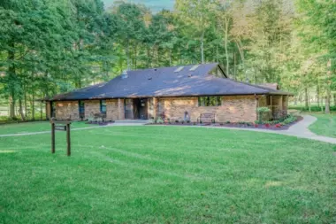 Exterior of a Woodland Grove Recovery residential building surrounded by lawn and mature trees.