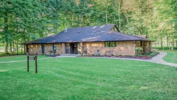Exterior of a Woodland Grove Recovery residential building surrounded by lawn and mature trees.