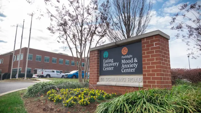 A brick sign with a green logo reads 