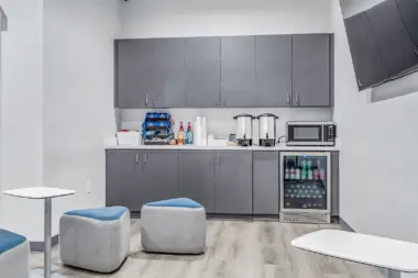 Common area kitchenette at Boca Recovery Center Huntington, featuring a microwave, fridge, and snack storage.