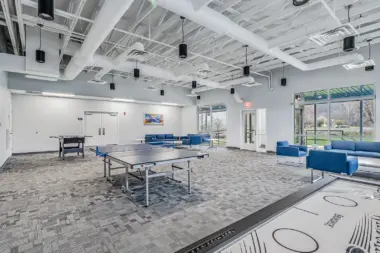 Recreational room at Boca Recovery Center Huntington featuring ping pong and foosball tables, comfortable seating, and large windows.