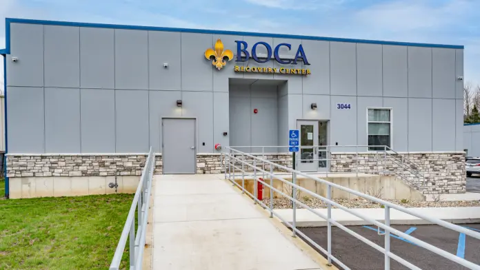 The front entrance of Boca Recovery Center Huntington, featuring the building's sign and accessible ramp.