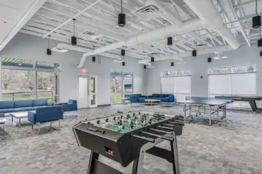 Recreation room at Boca Recovery Center Huntington featuring foosball, ping pong, and seating for relaxation.