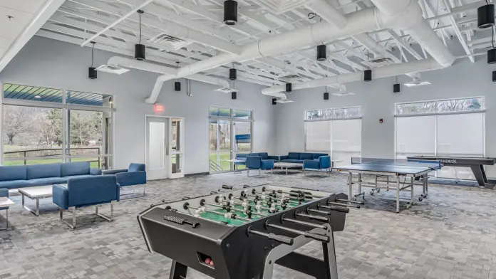 Recreation room at Boca Recovery Center Huntington featuring foosball, ping pong, and seating for relaxation.