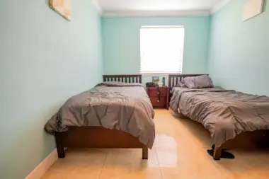 A bedroom at at Reign Residential Treatment Center in Southwest Ranches, FL with 2 comfortable beds