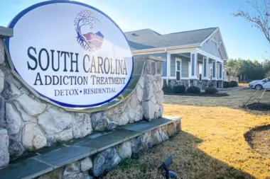 South Carolina Addiction Treatment center sign and building exterior on a sunny day. The large round sign reads 