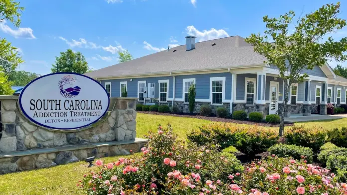 South Carolina Addiction Treatment center exterior with sign and blooming rose bushes. The sign reads