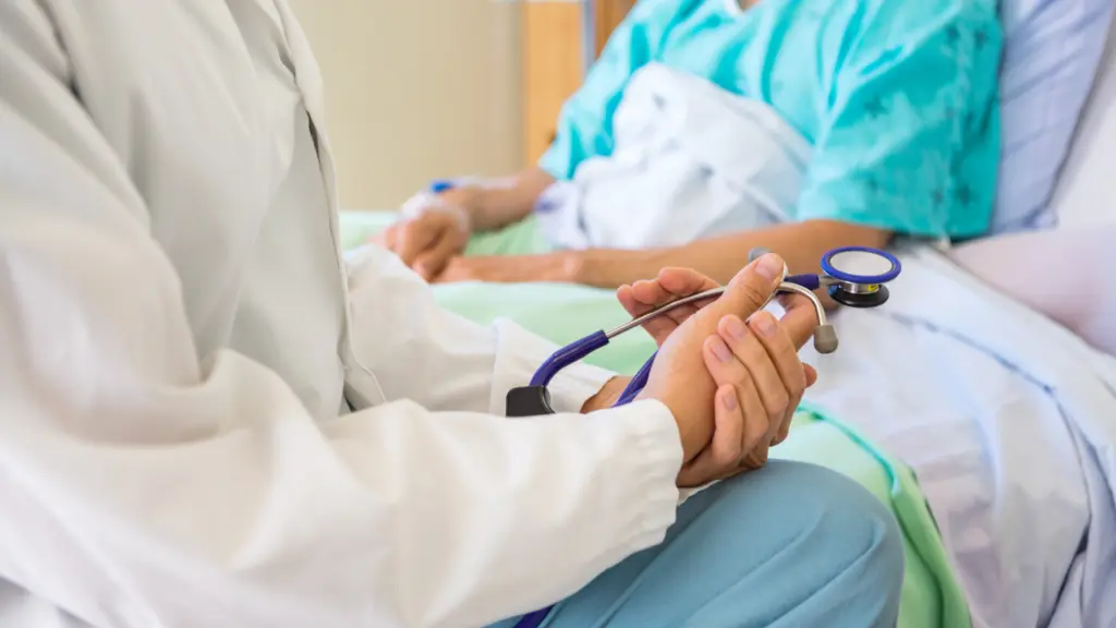 A doctor speaks with a patient in a hospital bed