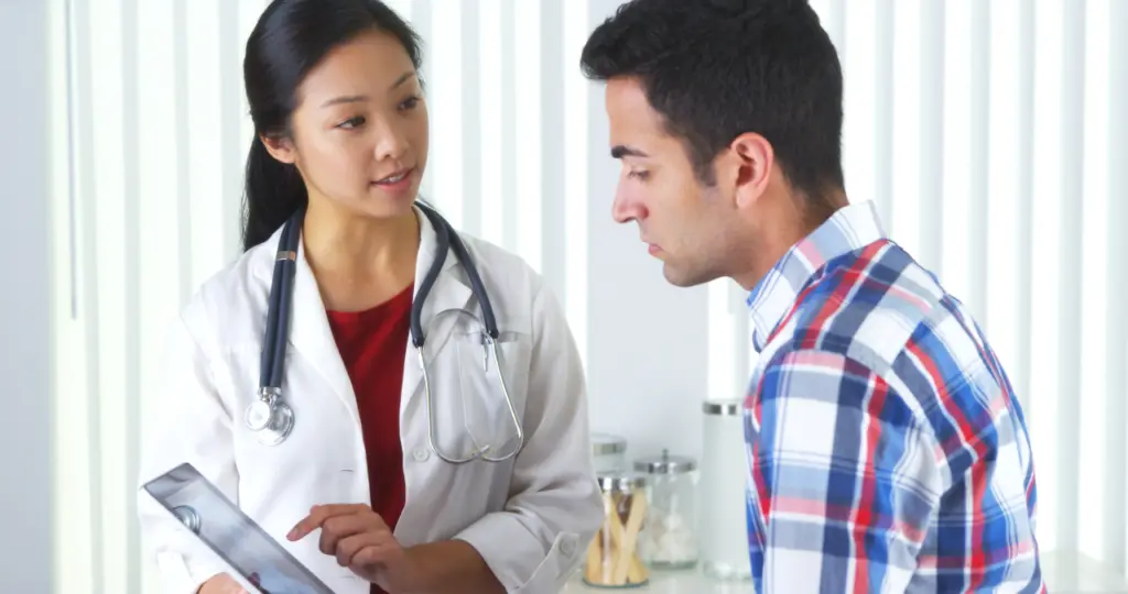 A doctor speaks with a patient during an appointment