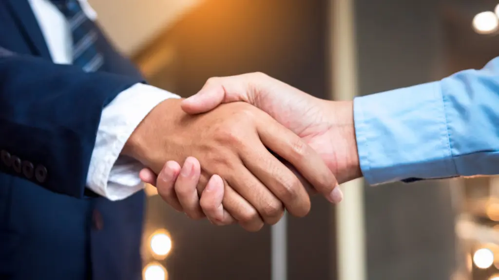 Two corporate workers shake hands