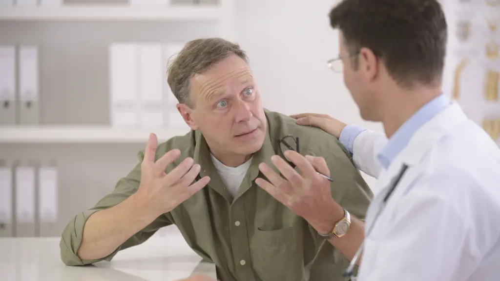 A doctor speaks with a distressed-looking patient