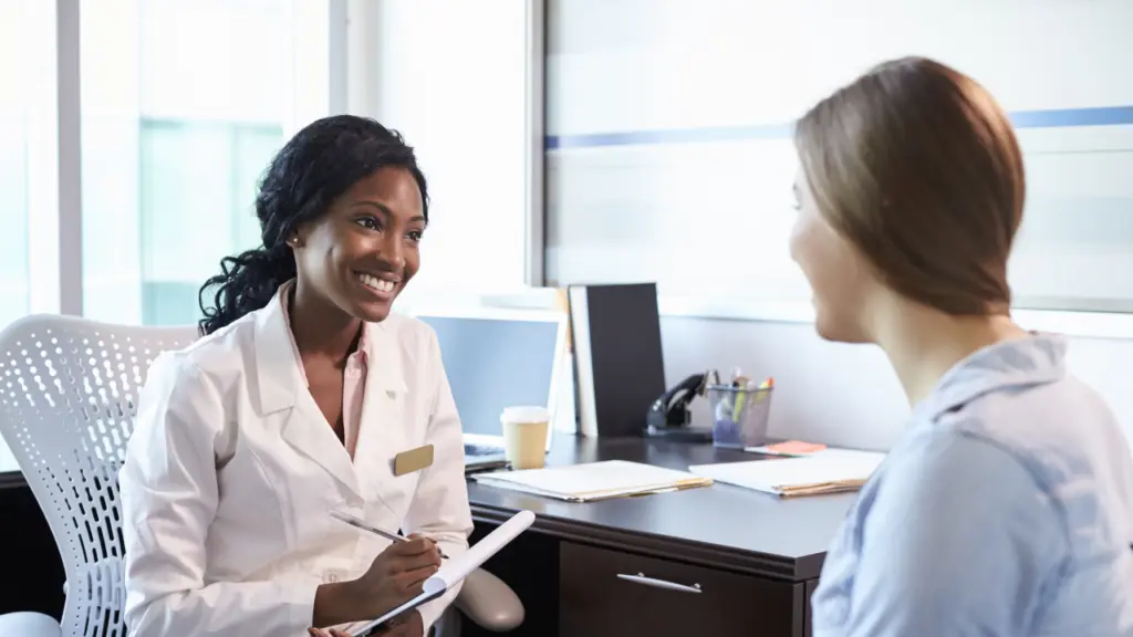 A doctor speaks with a patient at a consultation