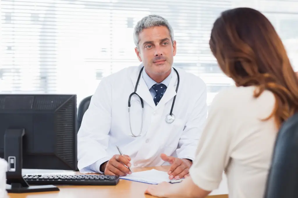 A doctor speaks with a patient during an appointment