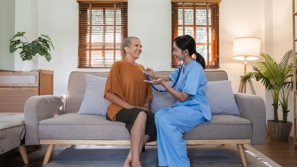 A doctor sits with a patient in a sober living home