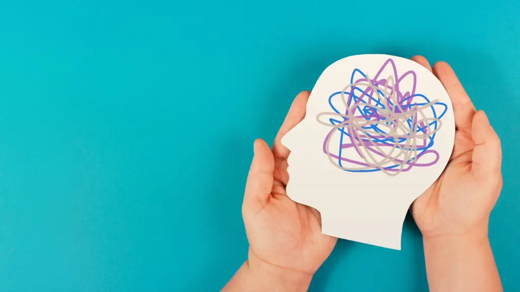 A pair of hands holds an artistic depiction of a head with mental illness