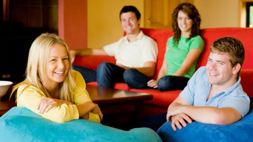 A group of smiling people hanging out in a sober living home