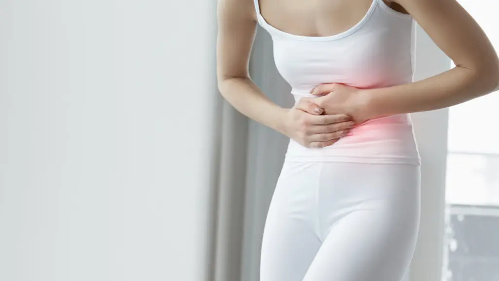 A woman clutches her stomach, suffering from digestive issues like diarrhea from alcohol withdrawal