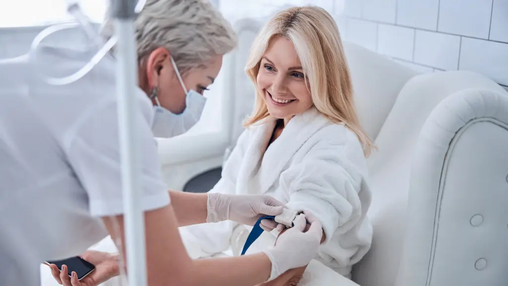 A doctor administers IV drip medication to a smiling patient