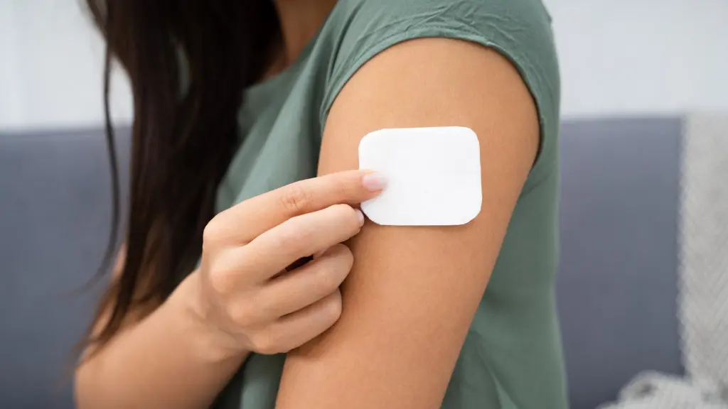 A person applies a medicated clonidine patch to help manage alcohol withdrawal