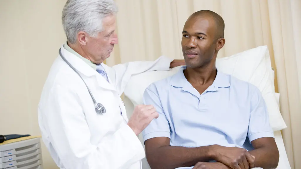 A doctor speaking with a patient during an alcohol withdrawal assessment