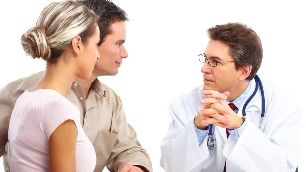 A patient and their partner sitting with a doctor during an assessment