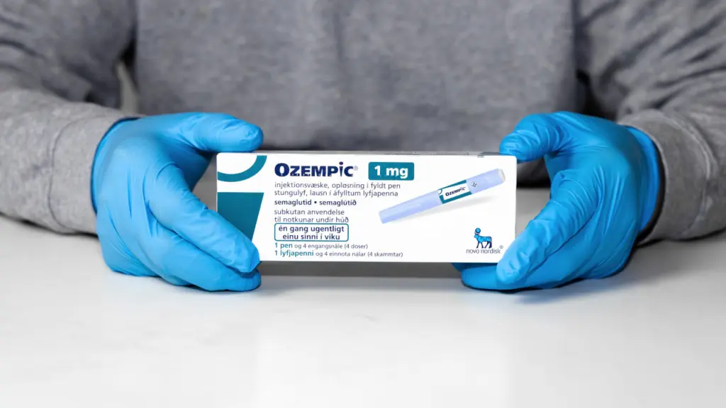 A person with gloved hands holds a box of Ozempic. Learn more about GLP-1 receptor agonists here.