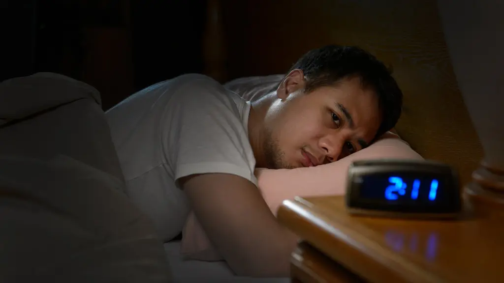 A man stuck awake in bed, suffering from insomnia. Learn more about sedative addiction here.