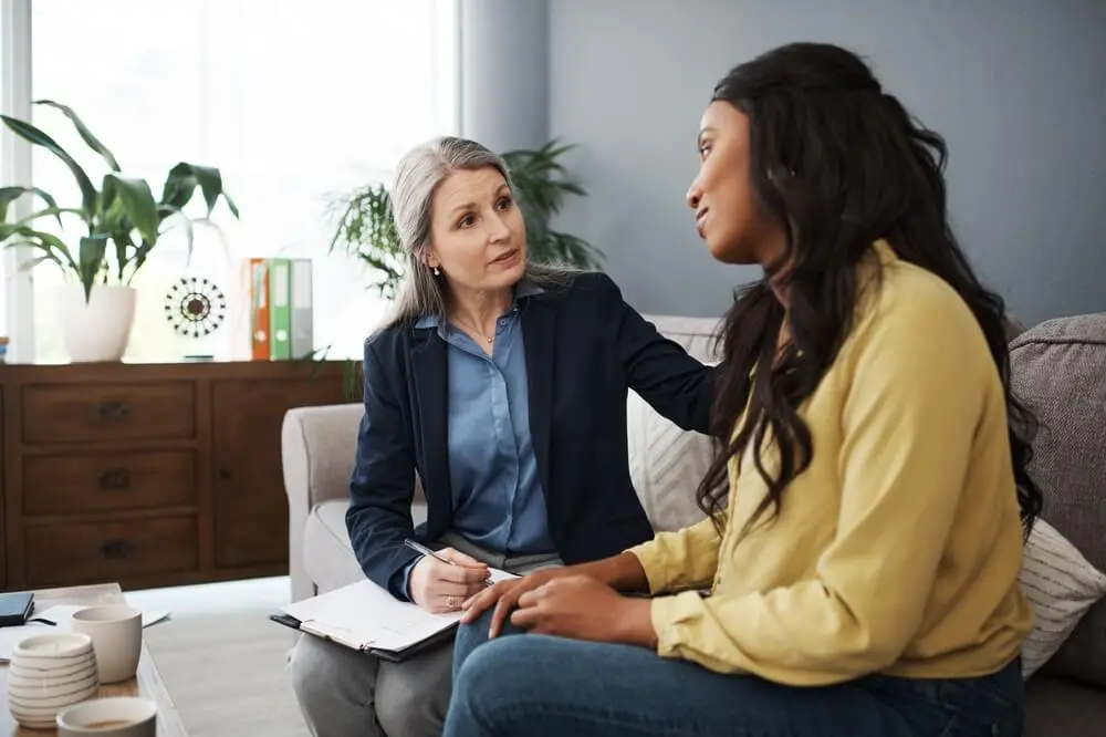 A woman speaking with a therapist. Learn more about trauma informed rehab here.