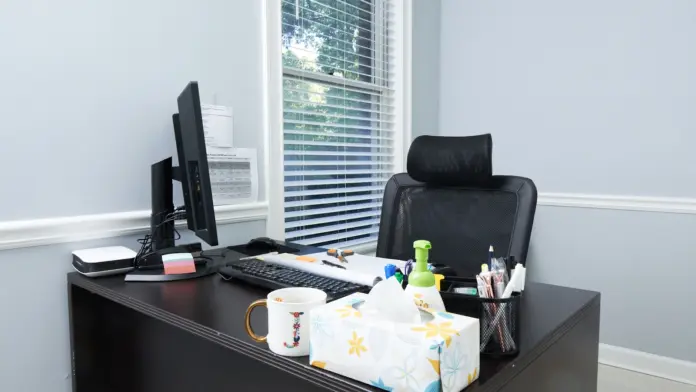Interior office desk with computer setup, office supplies, window blinds, and clean minimalist design