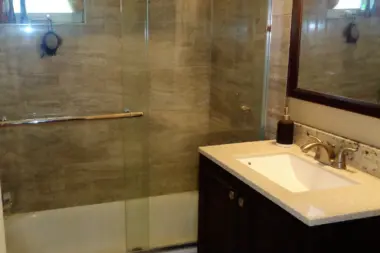 Interior bathroom featuring glass shower enclosure with tile surround and vanity with sink