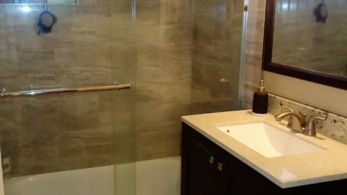 Interior bathroom featuring glass shower enclosure with tile surround and vanity with sink