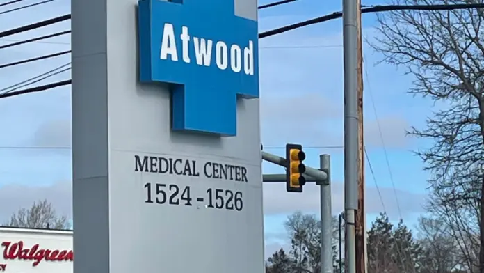 Exterior street signage for Atwood Medical Center at 1524-1526 with blue cross symbol and address marking