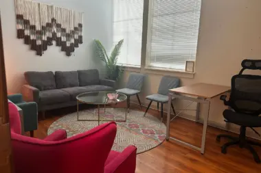 Interior common space with colorful seating arrangements, coffee table, and wall artwork